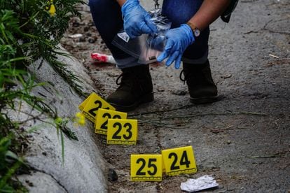 An expert collects the debris from the used ammunition after the shooting in the south of Mexico City. 