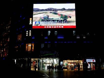A screen displays a broadcast of news footage of military vehicles under the Eastern Theatre Command of China's People's Liberation Army taking part in exercises around Taiwan.
