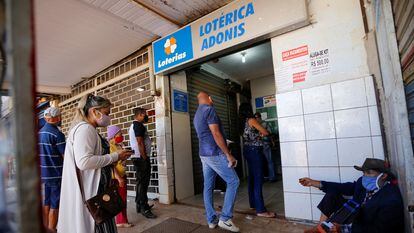 Citizens line up outside a lottery ticket sales point in the Ceilandia neighborhood of Brasilia in July 2020.