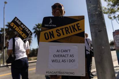 A protestor holds a poster reading 'AI Can't Overact as Well as I Do' as SAG-AFTRA members demonstrate in front of Netflix headquarters in Los Angeles, California, Nov. 8, 2023.
