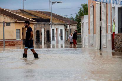 Residents of the neighborhood Huera de Abajo, in Molina de Segura, walk through the flooded streets.