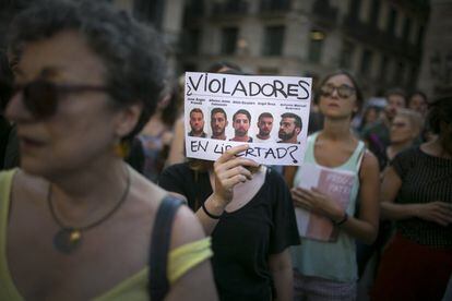 A woman holds a sign reading “Rapists freed?” with the faces “La Manada” during a protest in Barcelona.