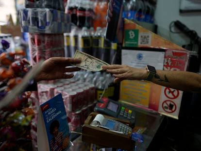A dollar changes hands in a store in Caracas, Venezuela.