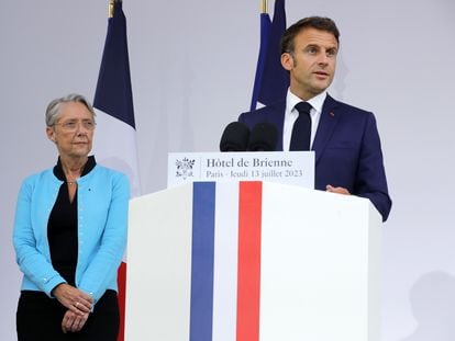 French President Emmanuel Macron flanked by Prime Minister Elisabeth Borne delivers his speech on the eve of Bastille Day, in Paris, France, 13 July 2023.