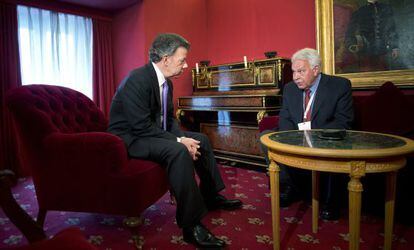 Colombian President Juan Manuel Santos speaks with former Spanish Prime Minister Felipe González on Monday in Madrid.