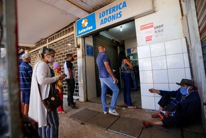 Citizens line up outside a lottery ticket sales point in the Ceilandia neighborhood of Brasilia in July 2020.