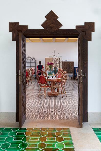The entrance to the dining room, with bespoke 'vermelho [vermillion]' pavement made at the Azeitão tile factory, which has been in operation in Portugal since the 16th century. Maison Gatti of Paris produced the colorful rattan bistro chairs. 