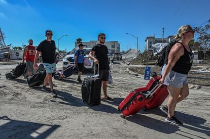 Residents of Fort Myers Beach leave their homes with the few belongings they could find after Hurricane Ian hit.