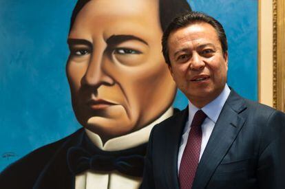 César Camacho Quiroz, stands before a portrait of Benito Juárez.