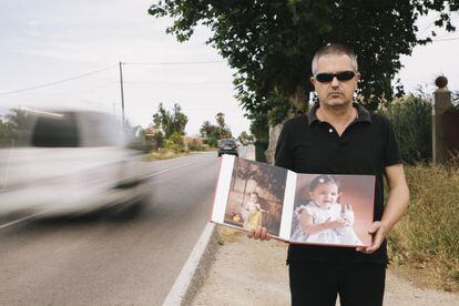 Antonio &Aacute;ngel Pertusa holds pictures of his daughter Julia near the scene of the accident.