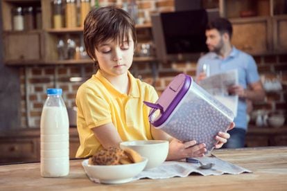 A child pouring out breakfast cereal.