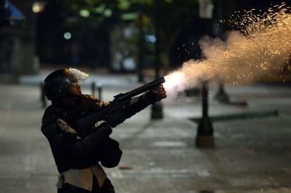 A member of the National Police shoots tear gas during clashes with anti-government demonstrators in Caracas Monday night.