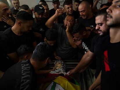Mourners chant anti Israel slogans while they take the last look at the body of Fares Abu Samra, 14, during his funeral in the West Bank city of Qalqilya, Thursday, July 27, 2023. The Palestinian Health Ministry said Thursday that Abu Samra was killed by Israeli fire in Qalqilya. The Israeli military said Palestinians threw rocks and firebombs at troops, who responded by firing into the air. It said the incident was being reviewed. (AP Photo/Nasser Nasser)