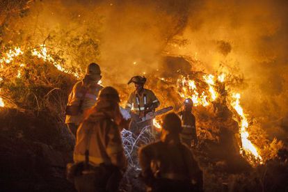 Firefighters labor to control the blaze near the Andalusian town of B&eacute;dar. 