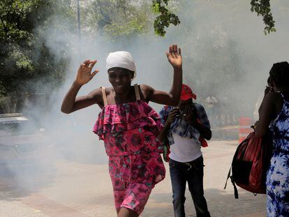 People flee from tear gas fired by officers of the Haitian National Police while clearing a camp of people escaping the threat of armed gangs, in front of the U.S. Embassy, in Port-au-Prince, on July 25, 2023.