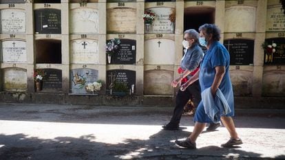 Two seniors wearing masks make a visit to a cemetery in Pamplona, northern Spain.