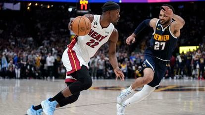 Miami Heat forward Jimmy Butler, left, moves the ball while defended by Denver Nuggets guard Jamal Murray, right, during the first half of Game 2 of basketball's NBA Finals, on June 4, 2023, in Denver.