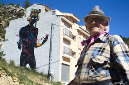 A Fanzara resident stands in front of one of the works of street art.