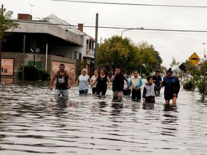 Residents wade through floodwater after heavy rains in La Plata on Wednesday.