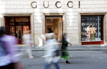 People walk outside a Gucci shop in Rome, April 20, 2023.