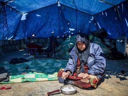 A woman eats outside the tent where she lives in Idlib (Syria), on the eve of the holy month of Ramadan.