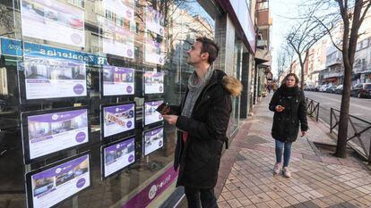 A young man reads property listings in Madrid.