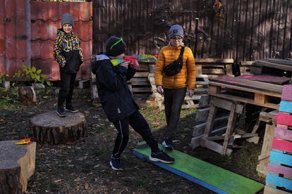 In Irpin, on Tuesday, November 1, a group of children play beside pallets that their parents will chop up to be used as firewood for the winter.