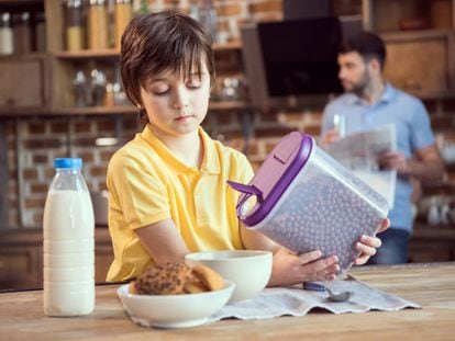 A child pouring out breakfast cereal.