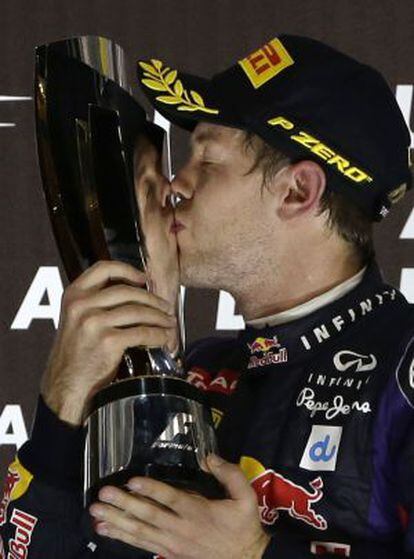 Red Bull driver Sebastian Vettel of Germany kisses the trophy on the podium after winning the Abu Dhabi Formula One Grand Prix.
