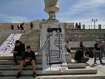 Young people pose next to a banner with the word "criminals" and another with a drawing representing a train crash victim in front of the Greek Parliament, last Friday.