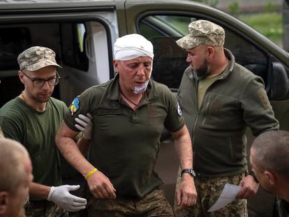 Ukrainian soldiers help their wounded fellow at a medical stabilisation point near Bakhmut, Donetsk region, Ukraine, Wednesday, May 24, 2023.