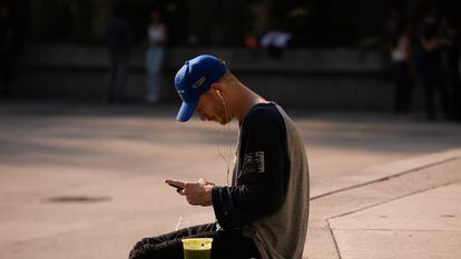 A young foreigner looks at his cell phone, in Mexico City.