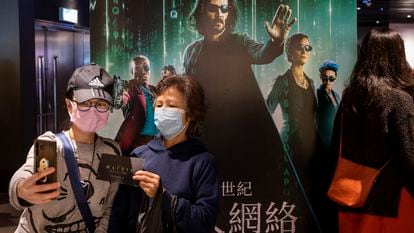 Moviegoers take a selfie in front of a movie banner for ‘The Matrix Resurrections’ at a cinema in Hong Kong.