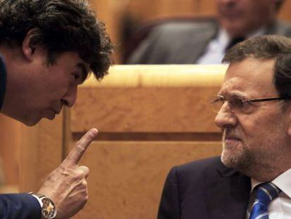 Jorge Moragas (l) speaks to Mariano Rajoy.