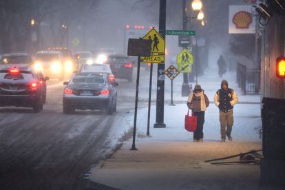 Pedestrians navigate a snow-covered sidewalk on December 22 in Chicago.