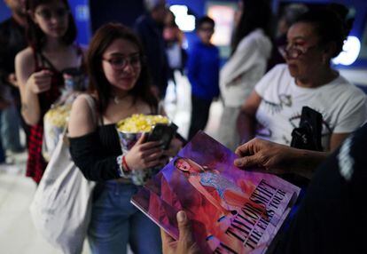 Several Taylor Swift fans collect a poster at the entrance of a cinema to see 'The Eras Tour' in Mexico City, on October 13, 2023.