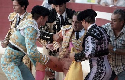 The injured bullfighter is taken by colleagues into the infirmary.