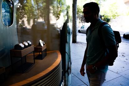 A man looks at a watch display on Madrid's upscale Serrano Street. 