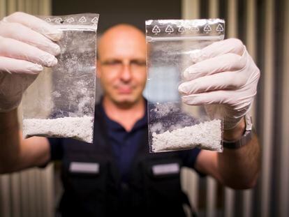 A police officer in Bavaria, Germany, displays two confiscated bags of methamphetamine; May 2014.