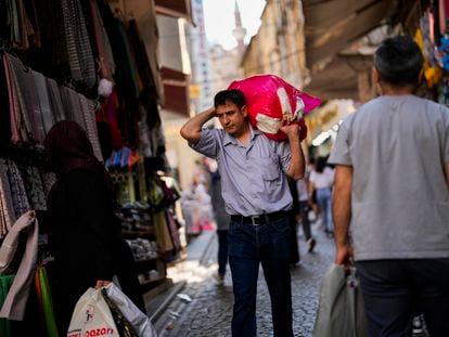 A man carries goods in a street market at Eminonu commercial area in Istanbul, Turkey,
