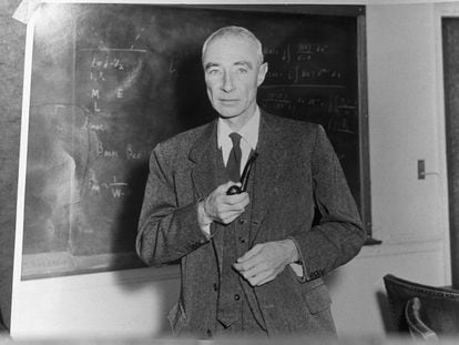 Robert Oppenheimer, standing before blackboard and holding pipe, in an undated photograph.