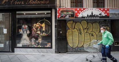 A man walks past closed stores during the coronavirus lockdown in Spain.