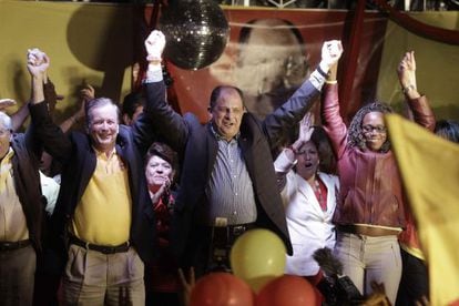 Luis Guillermo Solís (c) celebrates his victory on Sunday, which will take him to a runoff.