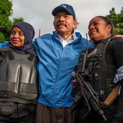 The president of NIcaragua, Daniel Ortega, poses with two police officers.