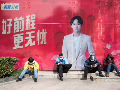 Cuatro repartidores con mascarillas junto a una boca de metro en Shangai, el mes pasado.
