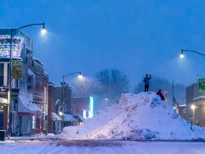 People play on an large snow pile in Oskaloosa, Iowa, Tuesday, Jan. 9, 2024.