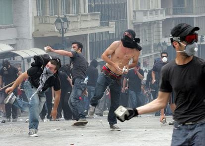 Anti-austerity protestors throw cobbles at the police outside the Greek parliament in May.