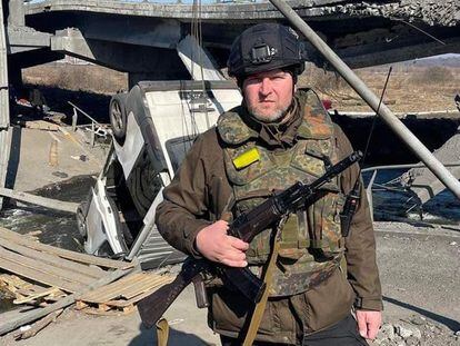 Oleksandr Markushyn poses in front of the bridge destroyed in Irpin to prevent the advance of Russian troops.