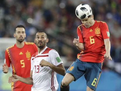 Iniesta heads the ball as Boutaib and Busquets look on.