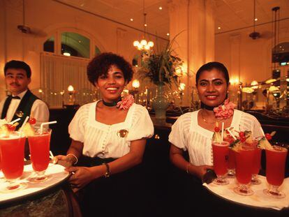 Waitresses serving Singapore Sling cockktails at the Raffles Hotel in Singapore.